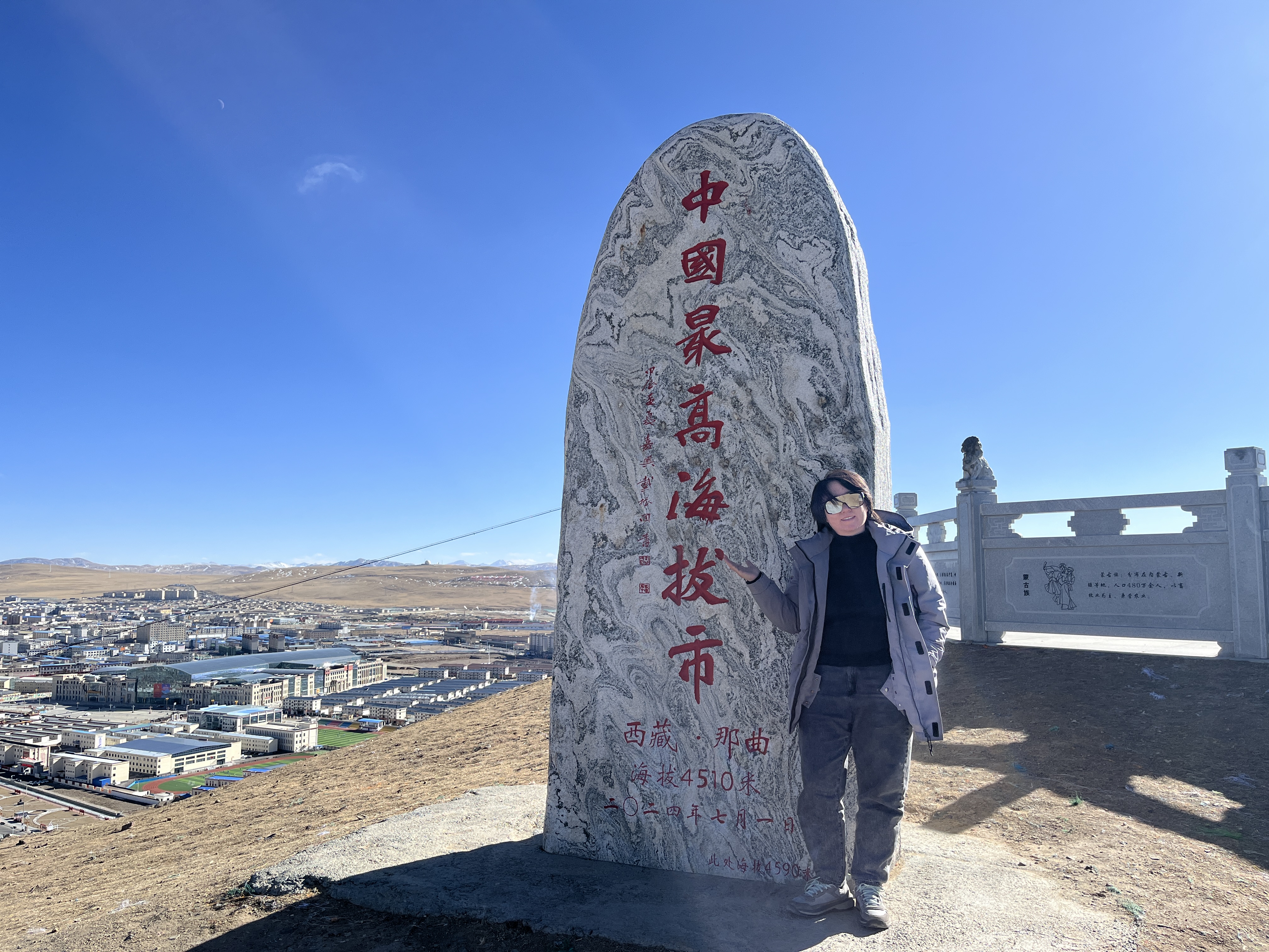 邓雅琪在中国最高海拔市纪念石旁