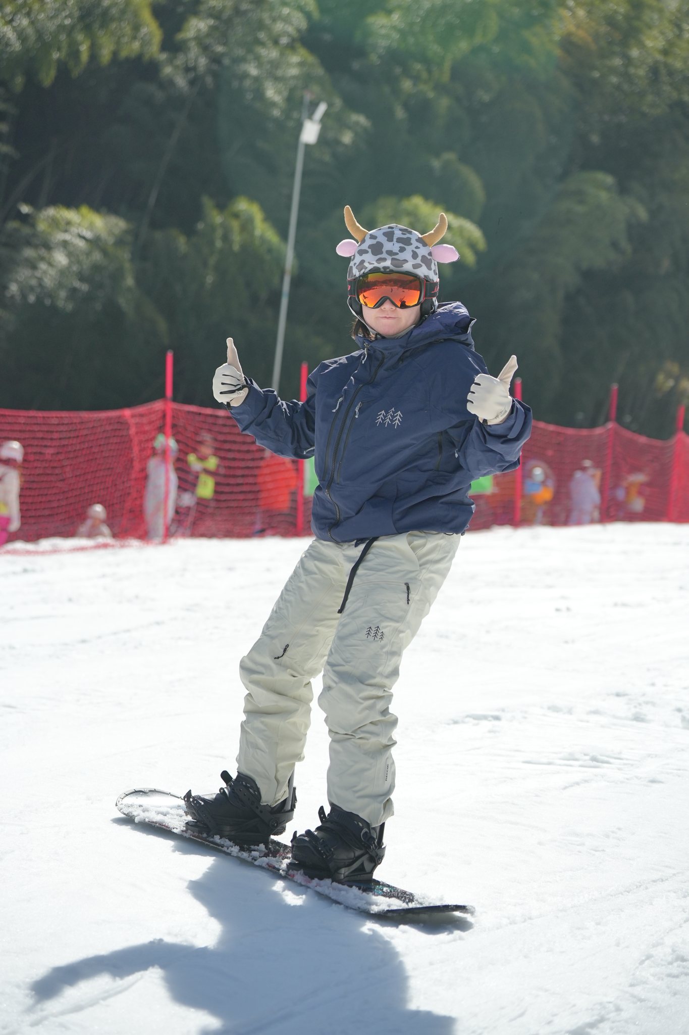 Une personne sur sa planche lève le pouce sur une piste enneigée